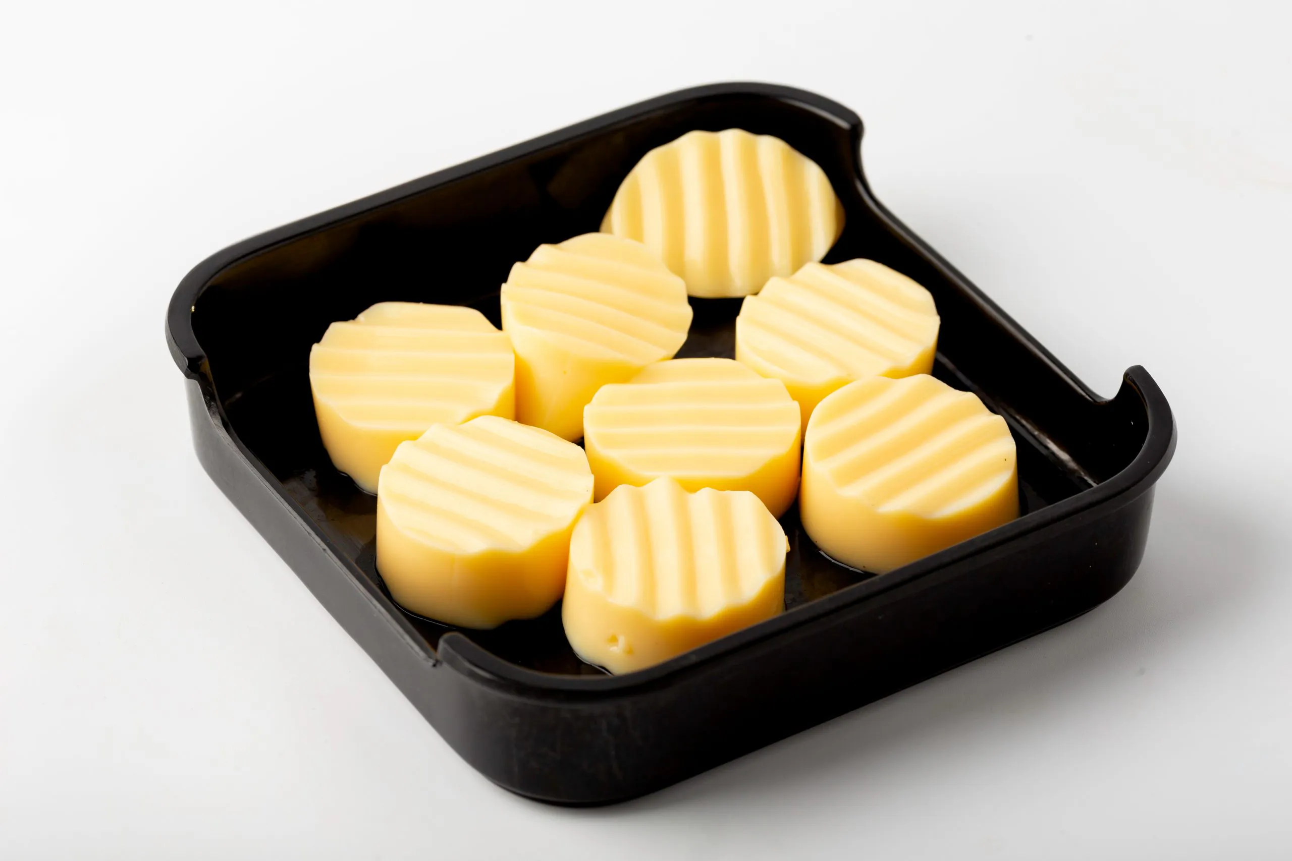 Slices of yellow egg tofu in a black tray at Firestone Hotpot & BBQ Restaurant in Tallahassee